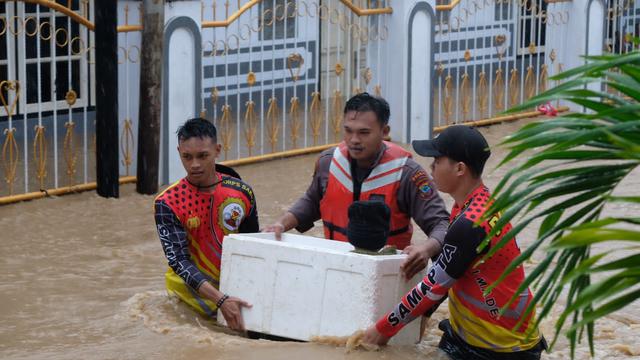 Aparat Polda Sulut dan Basarnas Manado mengevakuasi seorang balita yang terjebak banjir di Manado, Jumat (27/1/2023).