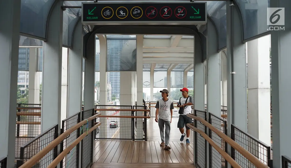 Pejalan kaki melintasi Jembatan Penyeberangan Orang (JPO) di kawasan Jenderal Sudirman, Jakarta, Minggu (1/9/2019). Pemprov DKI berencana membangun 15 JPO dengan bentuk lebih modern atau instagramable di sejumlah titik yang akan dilakukan pada 2020. (Liputan6.com/Immanuel Antonius)