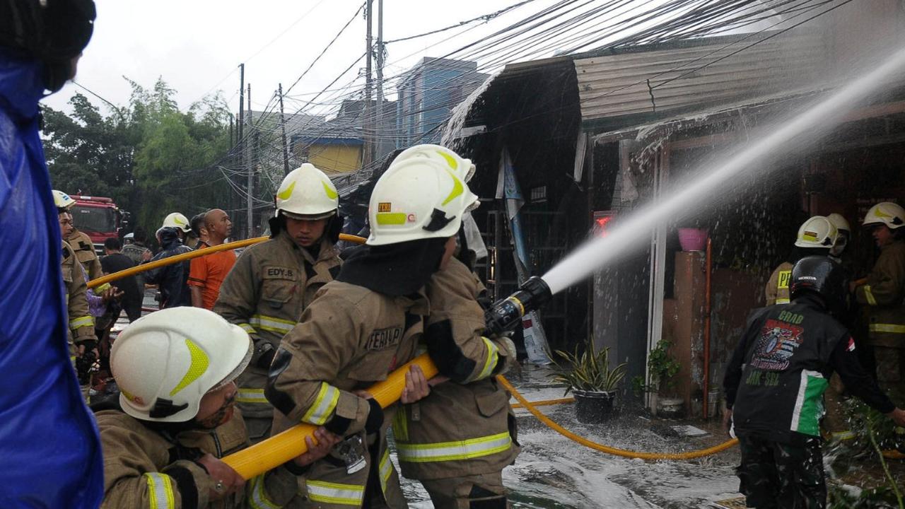 Petugas pemadam kebakaran berusaha memadamkan api yang membakar rumah di Kawasan Manggarai, Jakarta, Kamis (11/1/2024).