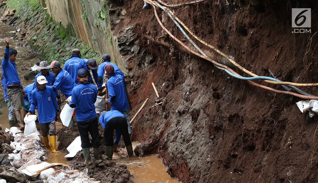 Petugas membongkar dinding turap di saluran air kawasan Pancoran, Jakarta, Senin (28/1). Pembongkaran dilakukan untuk mengganti batu penahan turap guna mencegah kelongsoran selama musim hujan. (Liputan6.com/Immanuel Antonius)