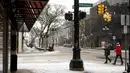 Dua wanita berjalan di Washington Street saat salju turun di Ann Arbor, Michigan, Rabu (2/2/2022). Badai salju membuat maskapai membatalkan ratusan penerbangan. (Jacob Hamilton/Ann Arbor News via AP)