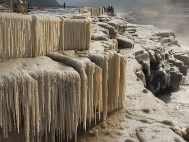 Wisatawan menikmati pemandangan musim dingin objek wisata Air Terjun Hukou di wilayah Jixian, Provinsi Shanxi, China utara, pada 9 Desember 2020. Air terjun Hukou terletak di daerah perbatasan antara Provinsi Shanxi di China utara dan Provinsi Shaanxi di China barat laut. (Xinhua/Lyu Guiming)
