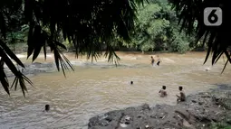 Anak-anak berenang di Kali Ciliwung, Depok, Jawa Barat, Minggu (27/6/2021). Keterbatasan lahan bermain di tengah masa pandemi COVID-19 membuat anak-anak memilih untuk berenang di Kali Ciliwung sebagai wahana alternatif saat libur sekolah. (merdeka.com/Iqbal S. Nugroho)