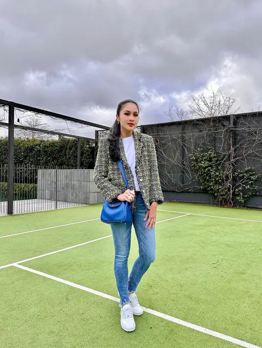 Padu padan blazer ala Sandra Dewi tidak pernah terlihat membosankan. Kali ini atasan kaus putih ditumpuknya dengan tweed blazer bernuansa kehijauan, dipadu dengan celana jeans, sling bag biru, dan sneakers putih. Foto: Instagram.