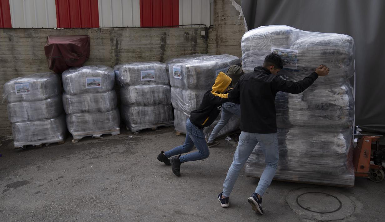 Para pekerja menyiapkan pengiriman perlengkapan tidur untuk para korban gempa bumi di Turki dan Suriah yang sekarang terkena cuaca musim dingin yang membekukan, di sebuah pabrik Palestina di kota Hebron, Tepi Barat, Kamis (16/2/2023).  Diketahui, gempa bumi mengguncang Turki dan Suriah dengan magnitudo 7,8 pada Senin (6/2/2023). Guncangan gempa itu diikuti oleh ratusan gempa susulan. (AP Photo/Nasser Nasser)