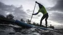 Seorang peserta mengambil bagian dalam Nautic Paddle Race di Paris, Minggu (9/12). Sekitar 800 orang mengikuti lomba dayung sambil berdiri terbesar di dunia sejauh 11 km menyeberangi sungai Seine. (Lucas BARIOULET/AFP)