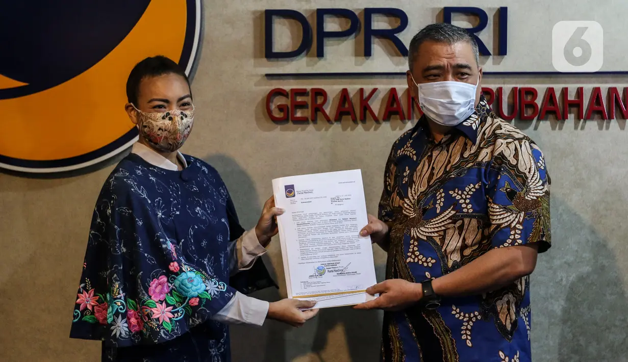 Wakil Ketua Umum DPP Partai NasDem Ahmad Ali (kanan) menyerahkan surat rekomendasi Pilkada kepada Calon Wakil Walikota Tangsel dari Partai Gerindra Rahayu Saraswati Djojohadikusumo (kiri)  di Kompleks Parlemen Senayan, Jakarta. Rabu (29/7/2020). (Liputan6.com/Johan Tallo)