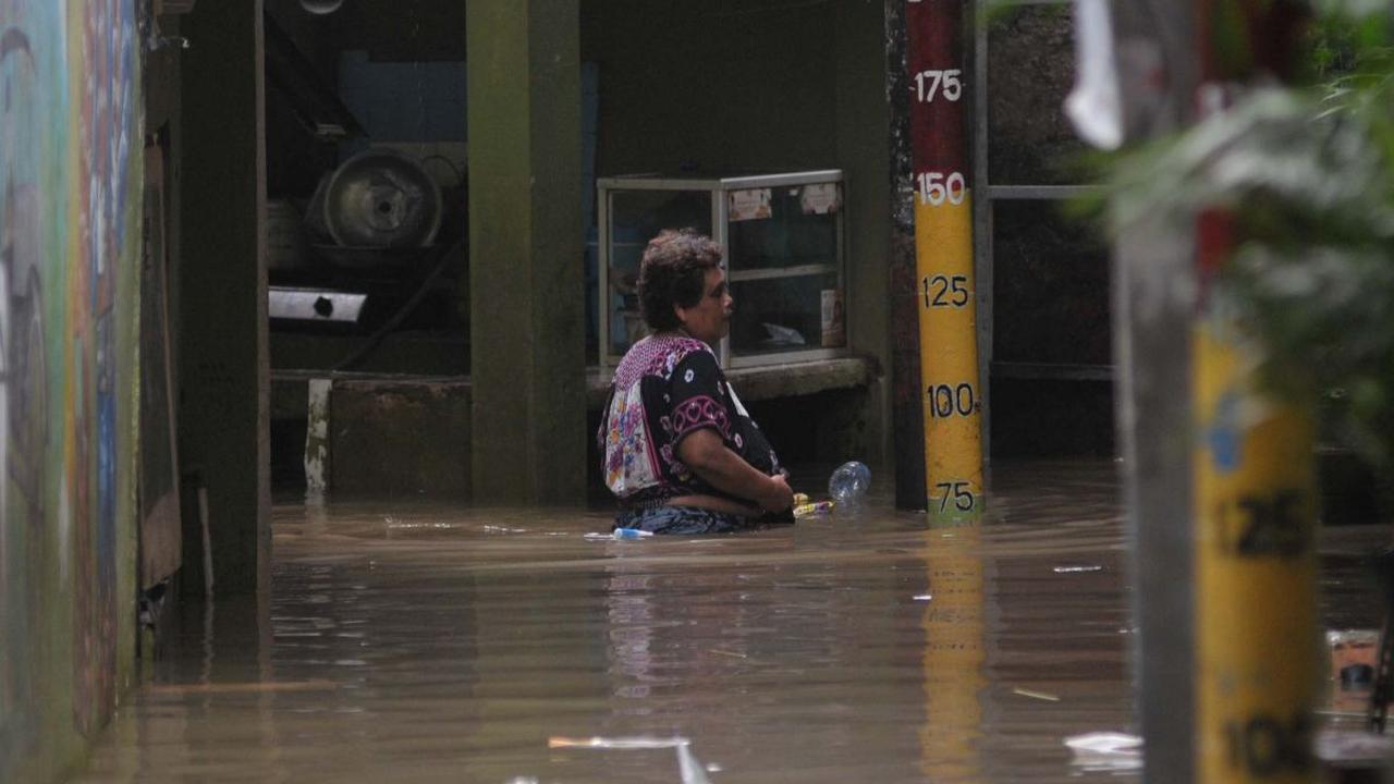 Seorang warga berjalan melewati banjir merendam permukiman di Kebon Pala, Jatinegara, Jakarta, Selasa (2/7/2024).&nbsp;Banjir ini terjadi akibat luapan Kali Ciliwung seiring tingginya intensitas hujan di wilayah Depok dan Bogor, Jawa Barat.&nbsp;Merdeka.c