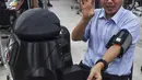 Profesor Viboon Sangveraphunsiri menunjukkan penggunaan robot medis yang dimodifikasi untuk memeriksa pasien virus corona COVID-19 di Regional Center of Robotics Technology, Chulalongkorn University, Bangkok, Thailand, Rabu (18/3/2020). (LILLIAN SUWANRUMPHA/AFP)