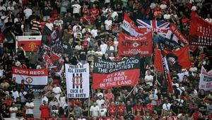Suporter mengibarkan bendera dan membentangkan spanduk di tribun penonton selama pertandingan Premier League antara Manchester United dan Arsenal di Old Trafford, Manchester, Inggris barat laut, pada 17 Agustus 2025. (Paul ELLIS/AFP)