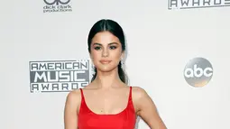 Pose Selena Gomez saat tiba di karpet merah perhelatan American Music Awards (AMA) 2016 di Los Angeles, California, Minggu (20/11). Dalam penampilan perdananya itu, Gomez terlihat sederhana dengan gaun merah polos. (REUTERS/Danny Moloshok)