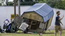 Sebuah mobil dan gedung utilitas bersandar satu sama lain di Waverly, Tennessee, Minggu (22/8/2021). Banjir parah yang melanda Middle Tennessee, AS, menyebabkan sedikitnya 22 orang tewas, sementara sekitar 50 orang lainnya dilaporkan masih hilang. (AP Photo/Mark Humphrey)