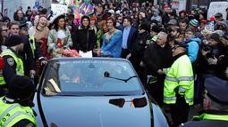 Aktris Mila Kunis berada di dalam mobil saat diarak dalam sebuah parade di Cambridge (25/1). Mila Kunis dinobatkan sebagai "Woman of the Year" oleh kelompok teater Hasty Pudding. (AP Photo / Charles Krupa)