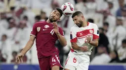 Pemain Qatar, Mohammed Waad Albayati, duel udara dengan pemain Lebanon, Hussein Zein, pada babak penyisihan Grup A Piala Asia 2023 di Stadion Lusail, Jumat (12/1/2024). Tuan rumah tampil agresif menekan sang tamu di sepanjang laga. (AP Photo/Aijaz Rahi)