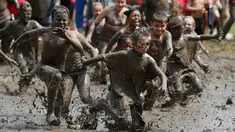 Anak-anak berlari ke dalam kubangan berisi lumpur saat Mud Day atau Hari Lumpur di Michigan, negara bagian AS, Selasa (9/7/2019). Para peserta perayaan yang menjadi tradisi setiap tahun ini merupakan anak-anak untuk agar mereka bersenang-senang selama liburan musim panas.  (AP/Carlos Osorio)