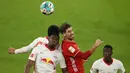 Bek RB Leipzig, Nordi Mukiele (kiri), berduel udara dengan gelandang Bayern Munich, Javier Martinez (tengah), dalam laga lanjutan Liga Jerman pekan ke-10 di Allianz Arena, Sabtu (5/12/2020). RB Leipzig bermain imbang 3-3 dengan Bayern Munich. (AFP/Alexander Hassenstein/Pool)