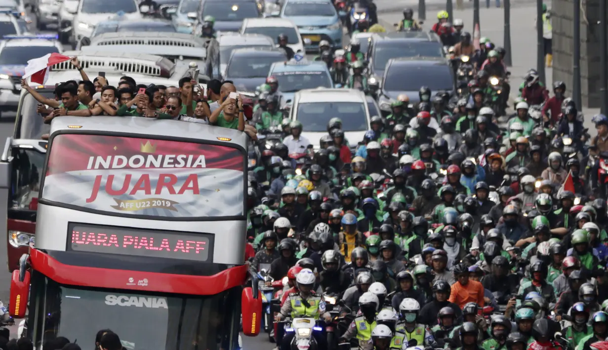 Pemain dan ofisial Timnas Indonesia U-22 menaiki bus tingkat saat konvoi menuju Istana Negara Jakarta, Kamis (28/2). Pawai tersebut untuk merayakan keberhasilan skuat Garuda Muda menjuarai Piala AFF U-22 di Kamboja. (Bola.com/M Iqbal Ichsan)