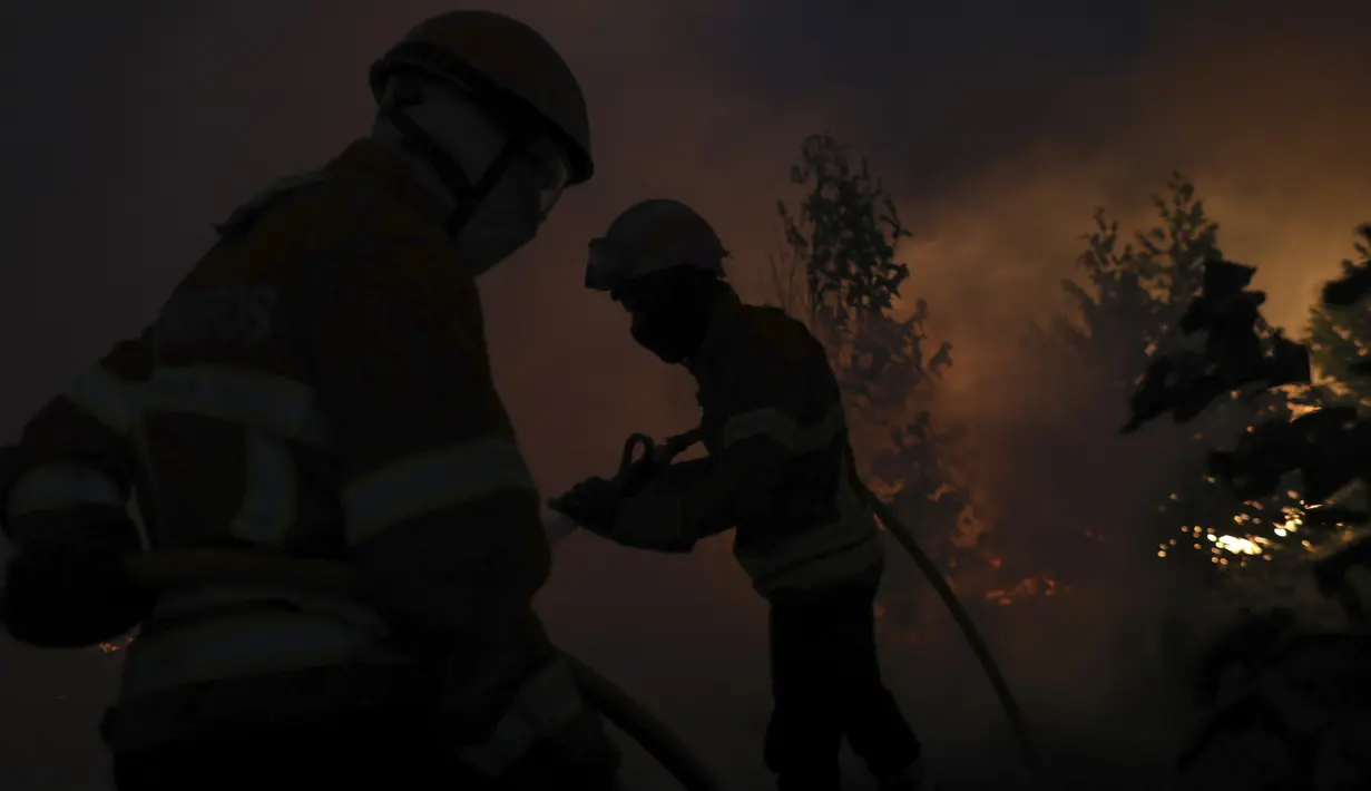 Petugas pemadam kebakaran berusaha memadamkan kebakaran hutan di daerah Rio Maior di Portugal, Rabu (17/8/2022). Pihak berwenang di Portugal mengatakan mereka berharap untuk mengendalikan api yang telah membakar selama 12 hari dan membakar petak besar hutan pinus di Taman Alam Serra da Estrela. (AP Photo/Joao Henriques)