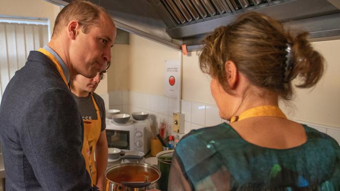 Pangeran William membantu menyiapkan makan siang saat mengunjungi Centrepoint di Barnsley, Inggris, Rabu (14/11). Centrepoint merupakan sebuah badan amal yang membantu para tunawisma. (Charlotte Graham / POOL / AFP)