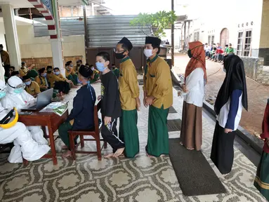 Para santri antre melakukan swab test di Pondok Pesantren Baitul Hikmah, Bojongsari, Depok, Jawa Barat, Kamis (12/11/2020). Pengelola pesantren bekerja sama dengan GTPPC Kota Depok dan RS UI melakukan swab test massal terhadap puluhan santri dan pengasuh pondok pesantren. (merdeka.com/Arie Basuki)