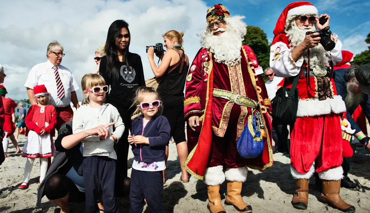 Anak-anak berpose dengan sinterklas dari seluruh dunia pada hari kedua Konvensi Musim Panas Sinterklas ke-59 di Kopenhagen, Denmark, 19 Juli 2016. Mereka memulai hari dengan berenang di pantai Bellevue. (Mathias Loevgreen Bojesen/Scanpix Denmark/AFP)