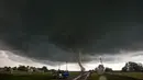Mobil berhenti di sisi jalan ketika tornado besar melewati daerah perumahan dari selatan Wynnewood, Kota Oklahoma, Senin (9/5). Tornado tersebut mendarat dengan cepat dan menghancurkan bangunan yang dilewatinya. (Josh EDELSON/AFP)