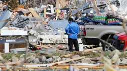 Seorang pria mencari barang-barang yang bisa dia selamatkan dari tokonya setelah tornado menerjang Cookeville, Tennessee, Amerika Serikat, Selasa (3/3/2020). Terjangan tornado menyebabkan kerusakan besar pada bangunan, jalan, jembatan, dan pusat bisnis. (AP Photo/Mark Humphrey)
