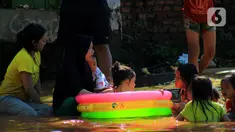 Sejumlah anak bermain air di Jalan Raya Kayu Putih, Jakarta, Minggu (23/2/2020). Usai hujan deras sejak Sabtu (22/2) malam hingga dini hari menyebabkan banjir di Jalan Raya Kayu Putih, Jakarta, Minggu (23/2). (merdeka.com/Magang/Muhammad Fayyadh)