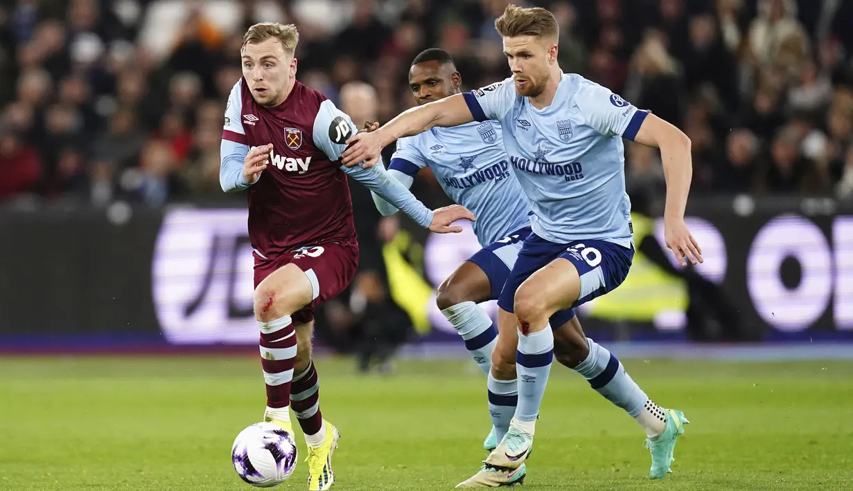 Pemain West Ham United, Jarrod Bowen (kiri) berebut bola dengan pemain Brentford, Kristoffer Ajer pada laga lanjutan Liga Inggris 2023/2024 di London Stadium, London, Inggris,Selasa (27/02/2024) dini hari WIB. (AP Photo/PA/Zac Goodwin)