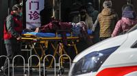 Seorang perempuan lanjut usia dengan tandu didorong ke klinik demam di sebuah rumah sakit di Beijing, Minggu (11/12/2022). China mengerahkan lebih banyak fasilitas perawatan intensif dan memperkuat layanan rumah sakitnya ketika menghadapi lonjakan kasus Covid-19. (AP Photo/Andy Wong)
