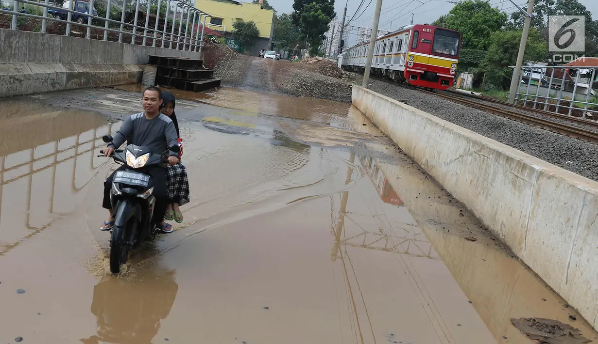 Pengendara motor melintasi genangan air di kawasan Kemiri Muka, Depok, Jawa Barat, Senin (2/10). Buruknya sistem drainase menyebabkan air selalu menggenang setiap musim hujan sehingga mengganggu aktivitas warga. (Liputan6.com/Immanuel Antonius)