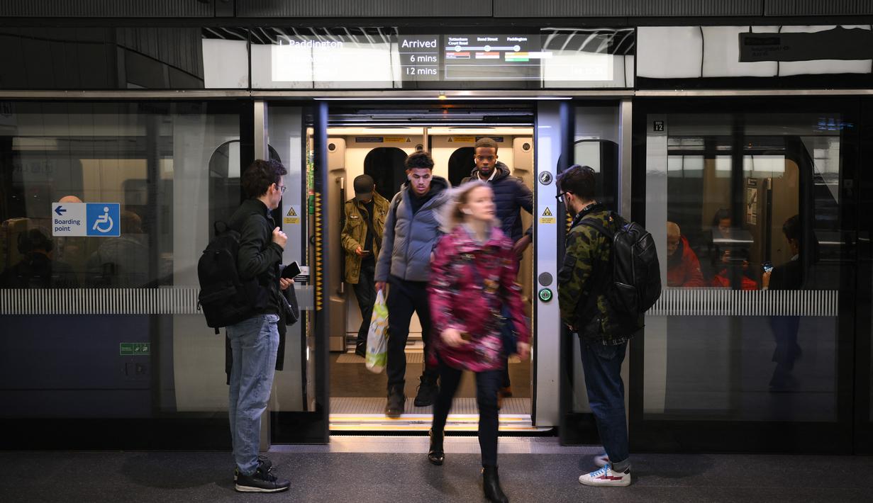 Penumpang tiba di stasiun kereta bawah tanah Canary Wharf Elizabeth Line yang baru dibuka di London Timur, Inggris, Senin (7/11/2022). Elizabeth Line mulai berjalan pada bulan Mei ketika dibuka oleh Ratu Elizabeth. (Daniel LEAL / AFP)