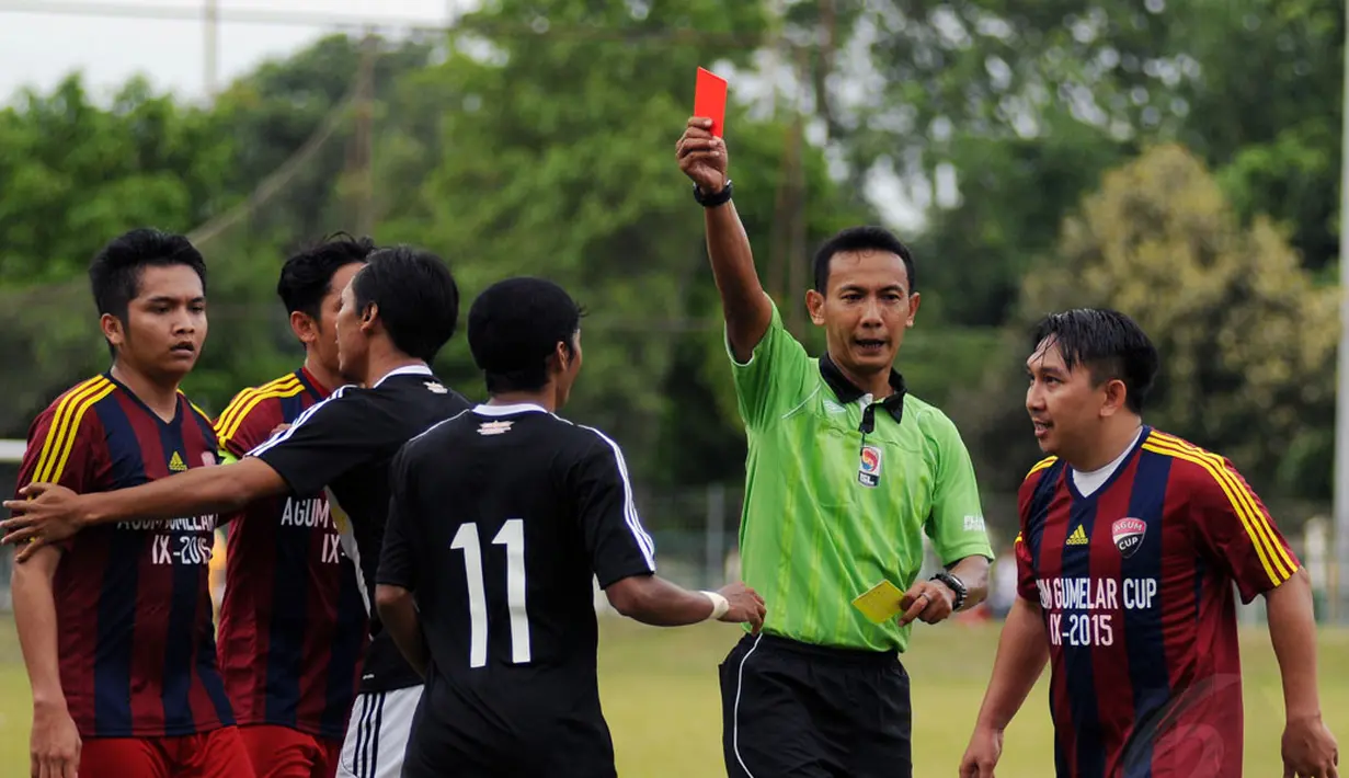 Salah satu pemain Paski-Man FC mendapat kartu merah dari wasit akibat melakukan tackling keras saat berlaga melawan Selebriti FC di turnamen Agum Gumelar Cup di Lapangan C Senayan, Jakarta (9/1/2015). (Liputan6.com/Helmi Fithriansyah)