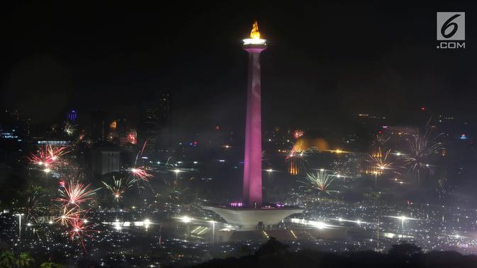 Kembang api menyala menyambut pergantian tahun 2018 ke 2019 di kawasan Monumen Nasional, Jakarta, Selasa (1/1). Hujan yang mengguyur Jakarta tidak menyurutkan warga menikmati kembang api tahun baru. (Liputan6.com/Helmi Fithriansyah)
