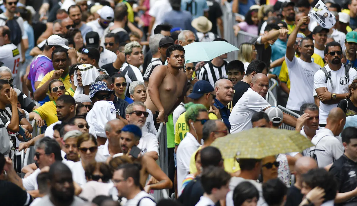 Warga Brasil mengantre untuk memberikan penghormatan terakhir kepada legenda sepak bola Brasil Pele di stadion Vila Belmiro di Santos, Brasil, Senin, 2 Januari 2023. Pele meninggal dunia di usia 82 setelah berjuang melawan penyakit kanker usus besar, Kamis (29/12/2022) waktu setempat. (AP Photo/Matias Delacroix)