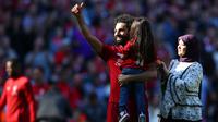 Pemain Liverpool Mohamed Salah menggendong putrinya Makka didampingi istrinya Maggi menyapa para suporter usai laga Liga Inggris menghadapi Wolverhampton Wanderers di di Stadion Anfield, Liverpool, Inggris, Minggu (12/5/2019). Liverpool gagal meraih gelar juara Liga Inggris. (AP Photo/Dave Thompson)