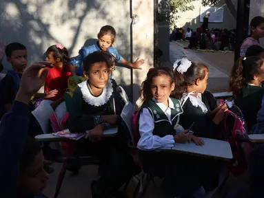 Anak-anak pengungsi Palestina menghadiri kelas di sebuah sekolah darurat di Khan Yunis di Jalur Gaza selatan pada 20 Oktober 2024. (BASHAR TALEB/AFP)