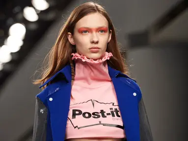 Model mengenakan crop top label Fyodor Golan edisi Fall/Winter 2017 dengan logo Post-it selama London Fashion Week di London, 17 Februari 2017. Label Inggris itu menunjukkan busana yang unik dan inspirasinya datang dari meja kerja. (NIKLAS HALLE'N/AFP)