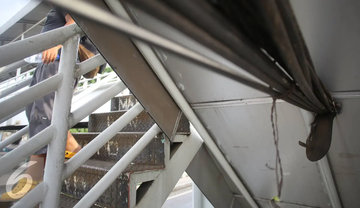 Kesemrawutan kabel yang menjuntai di JPO kawasan Cawang, Jakarta, Rabu (25/1). Selain mengganggu kenyamanan, buruknya penempatan instalasi kabel tersebut juga berbahaya bagi keselamatan pengguna JPO. (Liputan6.com/Immanuel Antonius)
