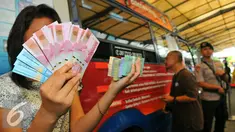Seorang wanita menunjukan beberapa mata uang baru di Blok M, Jakarta, Senin (19/12). Bank Indonesia (BI) hari ini meluncurkan 11 uang rupiah Emisi 2016 dengan gambar pahlawan baru. (Liputan6.com/Angga Yuniar)