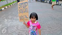 Anak - anak membawa papan bertuliskan " Stop Sampah Titik" saat melakukan aksi bersih - bersih sampah di Jakarta, (21/2). Anak-anak dan masyarakat luas bersama-bersama untuk memungut sampah. (Liputan6.com/Faisal R Syam)