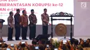 Presiden Jokowi (kanan) didampingi Ketua KPK, Agus Rahar (kedua kanan) bersiap memukul gong saat memperingati hari Antikorupsi Dunia di Jakarta, Senin (11/12). (Liputan6.com/Angga Yuniar)