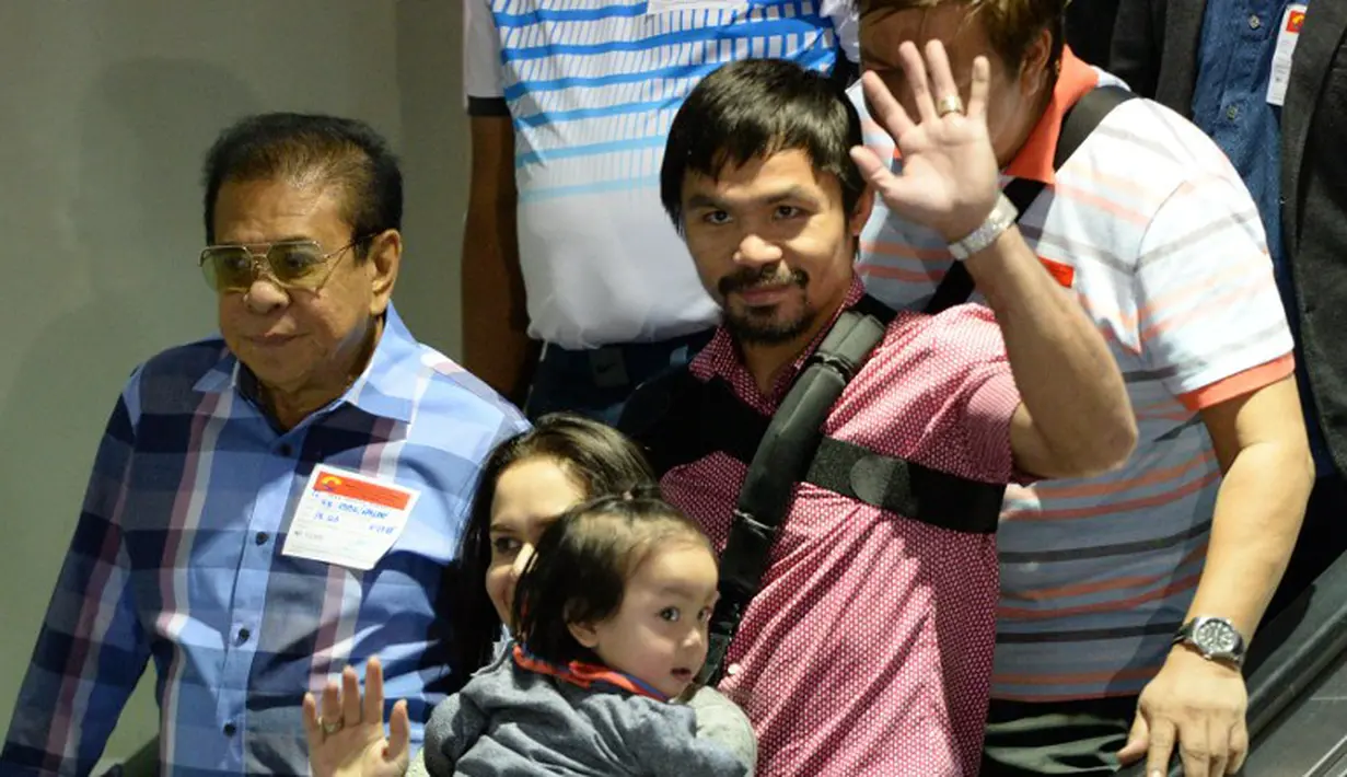 Manny Pacquiao dan istrinya ,Jinkee, saat tiba di Bandar Udara Internasional Manila, Filipina setelah pertarungannya melawan Floyd Mayweather. (AFP PHOTO/TED ALJIBE)