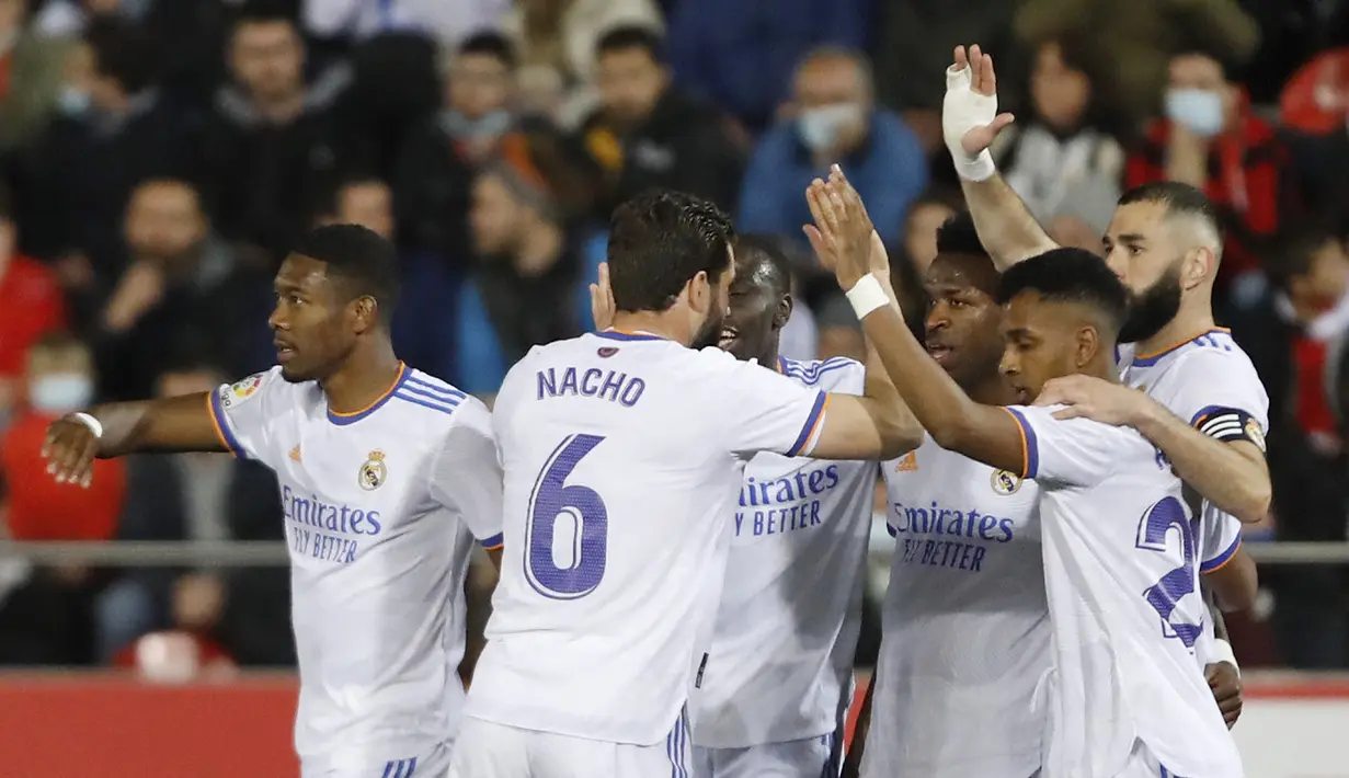 Penyerang Real Madrid, Vinicius Junior (keempat kiri) berselebrasi dengan rekan satu timnya usai mencetak gol ke gawang Mallorca pada pertandingan lanjutan La Liga Spanyol di Palma de Mallorca, Spanyol, Selasa (15/3/2022). Madrid menang telak atas Mallorca 3-0. (AP Photo/Francisco Ubilla)