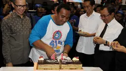 Jokowi tersenyum mendapat potongan kue ulang tahun. Priyo sedang menunggu giliran (Liputan6.com/Johan Tallo).