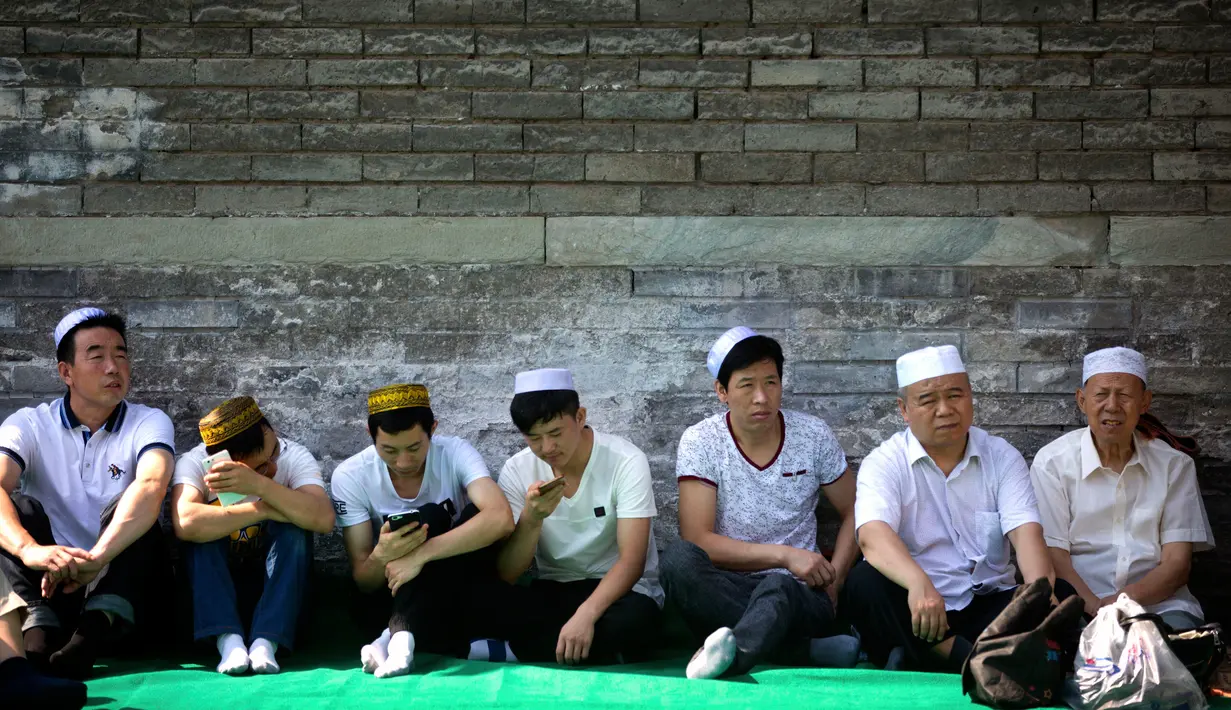 Umat muslim Cina menunggu dimulainya pelaksanaan salat Idul Fitri di masjid Niujie, Beijing, 26 Juni 2017. Masjid Niujie merupakan Masjid bersejarah di Kota Beijing dan mnjadi tempat ibadah masyarakat muslim. (AP Photo/Mark Schiefelbein)