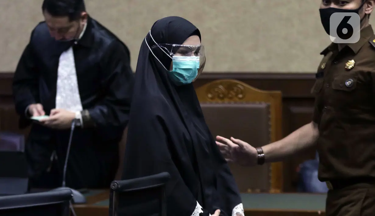 Terdakwa suap dan TPPU terkait pengurusan fatwa Mahkamah Agung untuk Djoko S Tjandra, Pinangki Sirna Malasari (tengah) saat jeda sidang pembacaan putusan di Pengadilan Tipikor Jakarta, Senin (8/2/2021). Sebelumnya, Pinangki dituntut hukuman empat tahun penjara. (Liputan6.com/Helmi Fithriansyah)