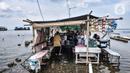 Warga tetap membuka warung meski terendam banjir rob di Pelabuhan Kali Adem, Muara Angke, Jakarta, Kamis (22/10/2020). Banjir akibat air pasang dengan ketinggian mencapai 30 cm tersebut telah merendam kawasan Pelabuhan Kali Adem dan sudah berlangsung selama lima hari. (merdeka.com/Iqbal S. Nugroho)