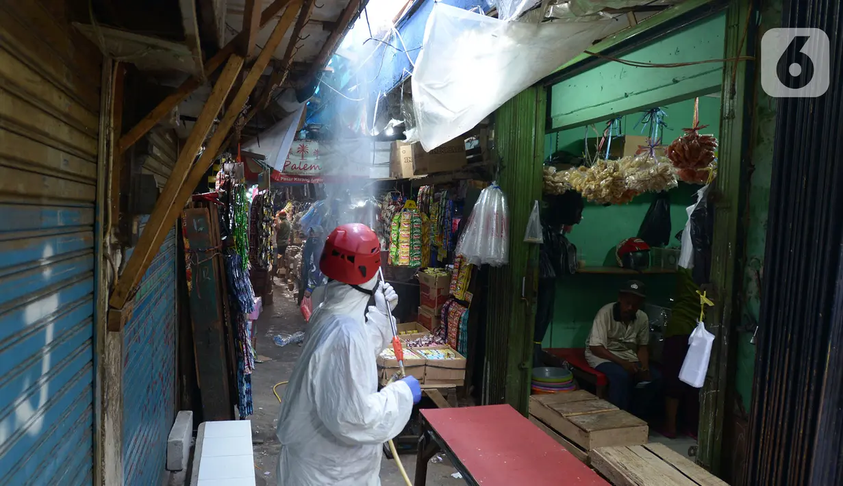 Petugas Palang Merah Indonesia (PMI) melakukan spraying pasar Karang Anyar dengan cairan disinfektan, Jakarta Pusat, Rabu (24/6/2020). Penyemprotan cairan disinfektan yang dilakukan tesebut untuk memutus penyebaran virus corona (COVID-19) pada PSBB Transisi new normal. (merdeka.com/Imam Buhori)