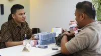 Petugas melayani penyetoran uang di cabang Bank Mandiri Pertamina UPMS III, Jakarta, Rabu (28/6). Bank Mandiri mengoperasikan 319 kantor cabang se-Indonesia secara bergantian pada musim liburan Idul Fitri 26-30 Juni 2017. (Liputan6.com/Angga Yuniar)